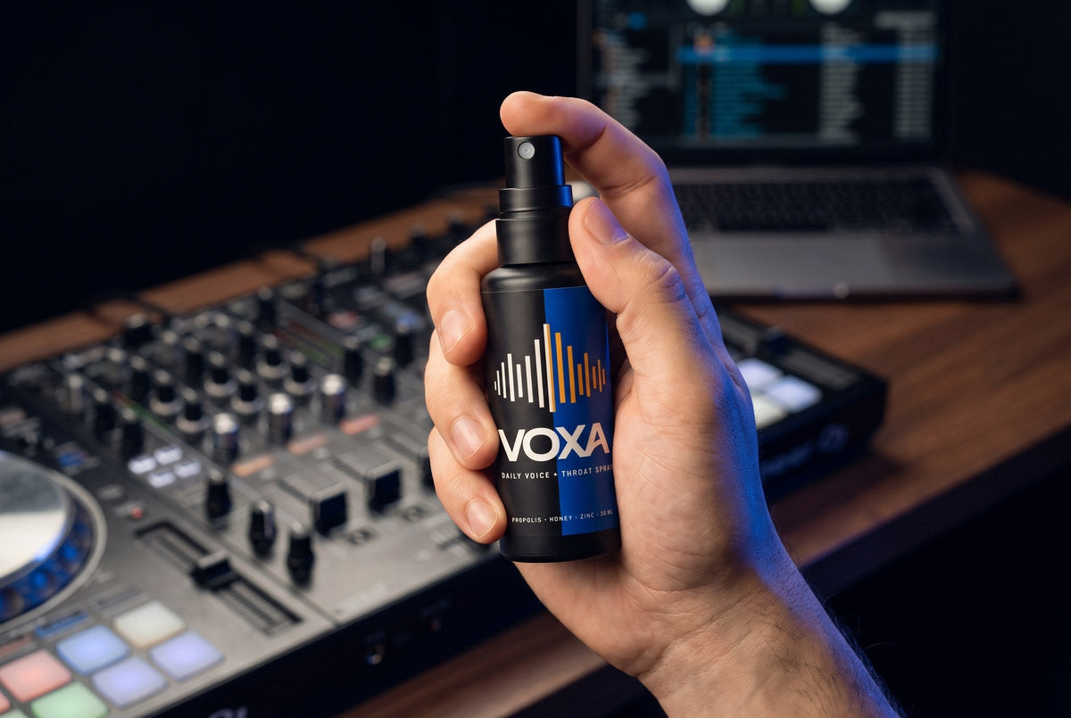A hand holding the VOXA 30 ml bottle at a mixer, showing its pocket size